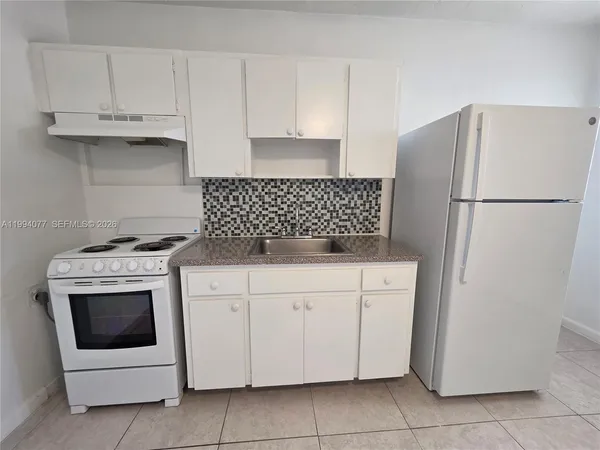 a kitchen with white cabinets and white appliances