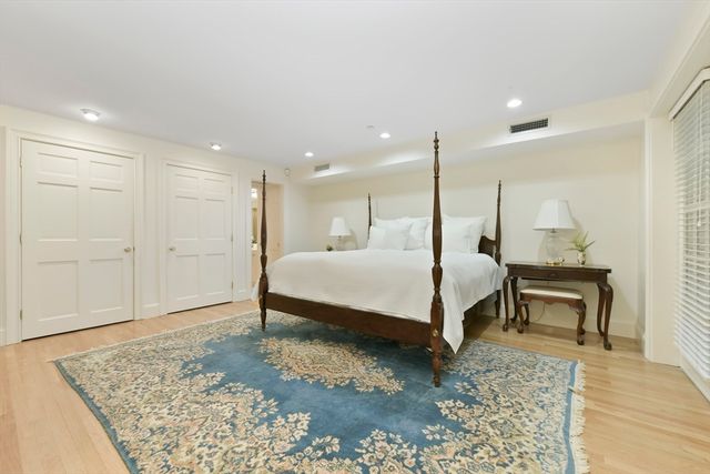 a bedroom with a bed lamps and a table