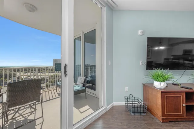 a living room with furniture a flat screen tv and a floor to ceiling window