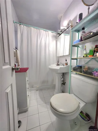 a bathroom with a sink a toilet and shower curtain