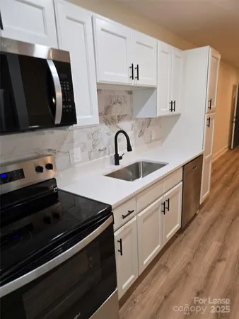 a kitchen with granite countertop a stove and a sink
