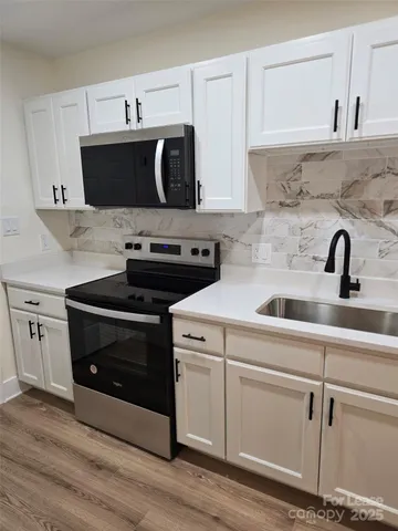 a kitchen with stainless steel appliances a sink a stove and cabinets