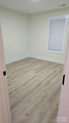 a view of an empty room and wooden floor
