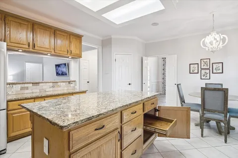 a kitchen with granite countertop cabinets and chair