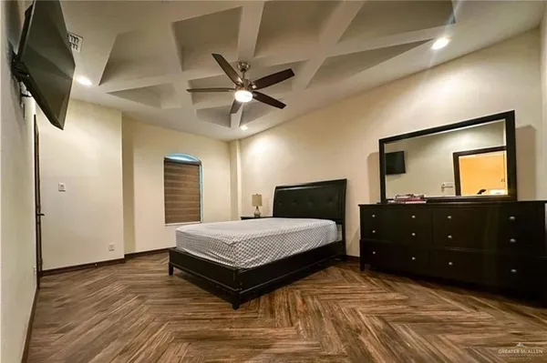 a spacious bedroom with a bed and a flat screen tv