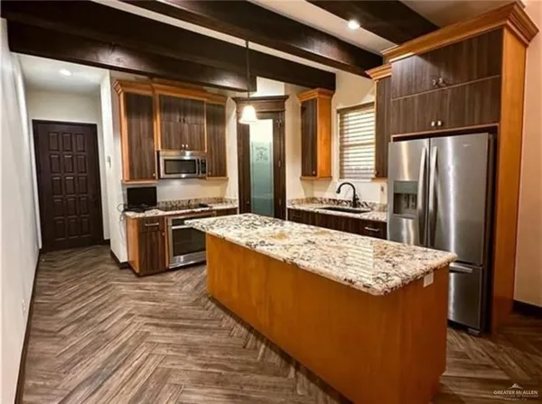 a kitchen with stainless steel appliances granite countertop a refrigerator a stove and a sink