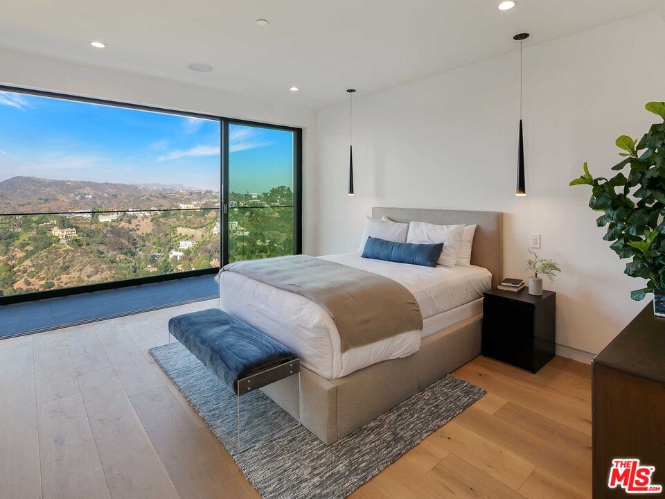 1324 Stradella Road Los Angeles, CA 90077 - Photo 15 of 26 a bed sitting in a bedroom next to a large window