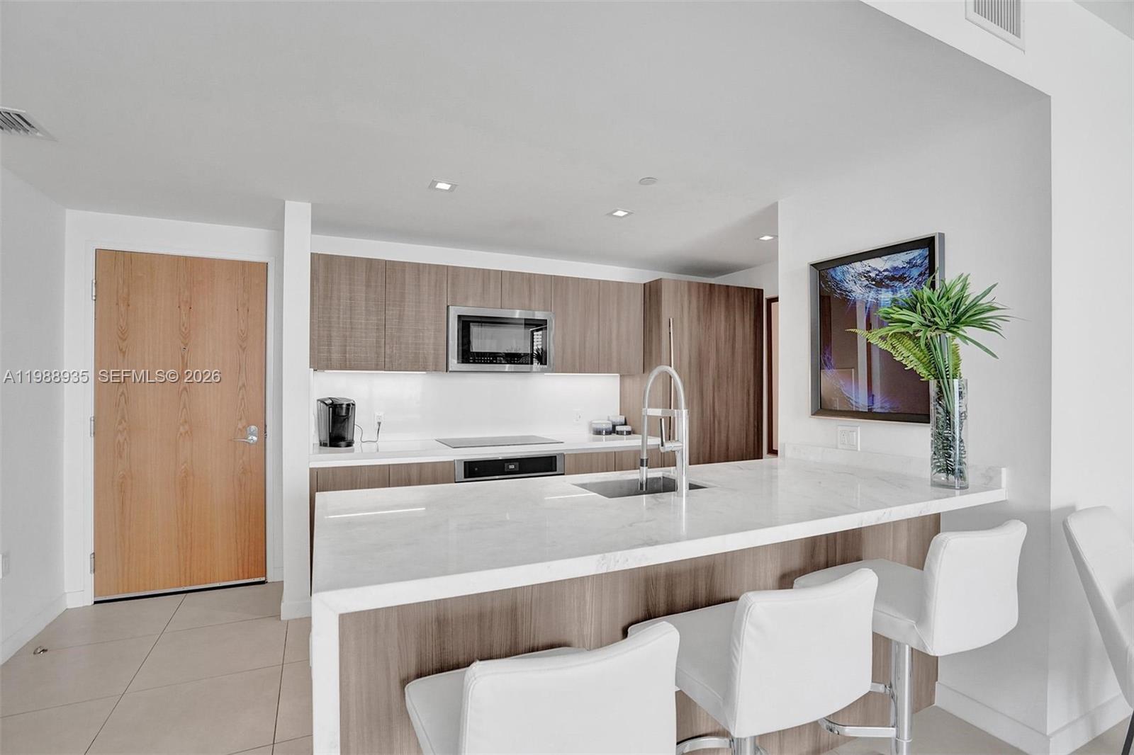 401 North Birch Road, Unit 513 Fort Lauderdale, FL 33304 - Photo 20 of 37 a kitchen with stainless steel appliances a sink and a refrigerator