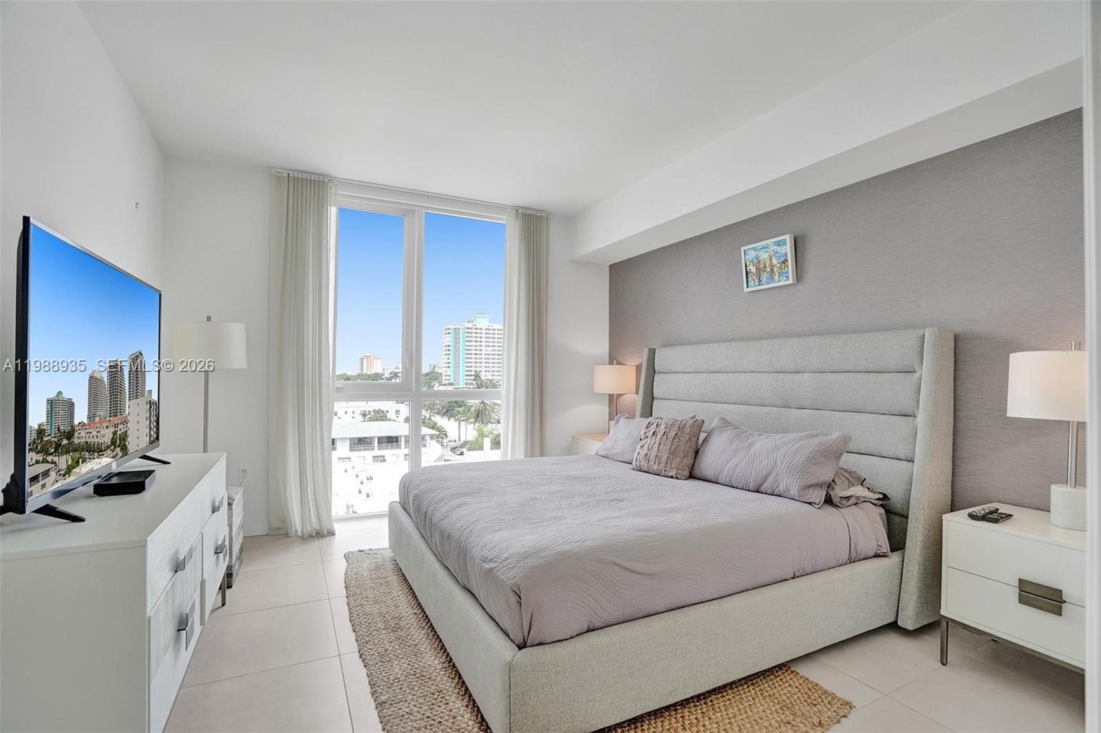 401 North Birch Road, Unit 513 Fort Lauderdale, FL 33304 - Photo 5 of 37 a bedroom with a bed a large window and a couch