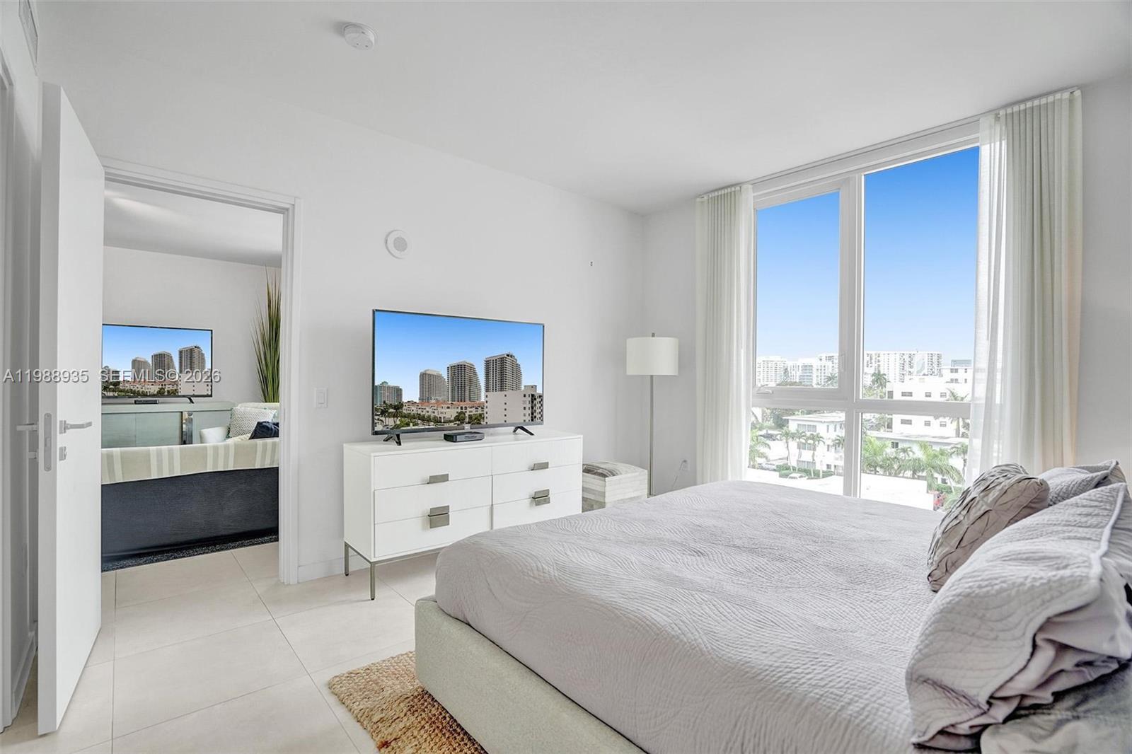 401 North Birch Road, Unit 513 Fort Lauderdale, FL 33304 - Photo 8 of 37 a large white bedroom with a large bed and a window