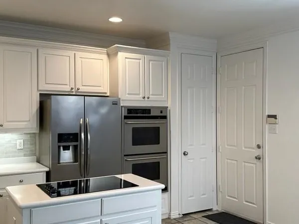 a kitchen with a refrigerator sink and cabinets