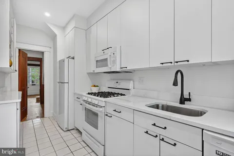 a kitchen with appliances a sink and cabinets