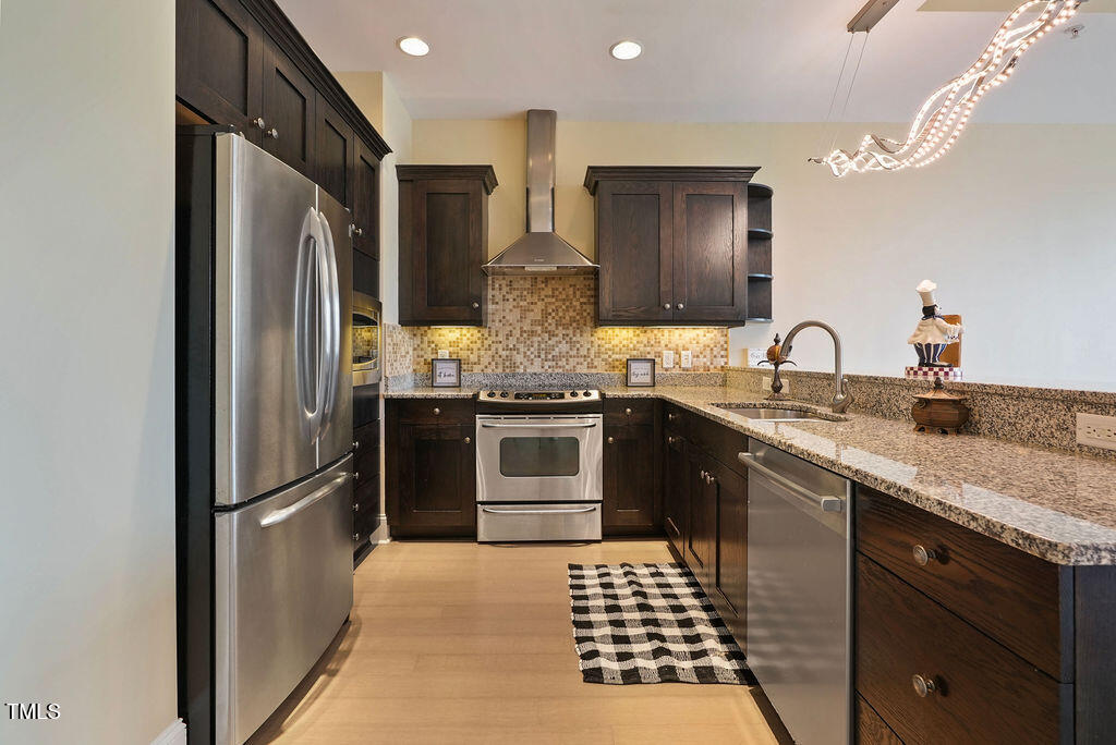 400 West North Street, Unit 604 Raleigh, NC 27603 - Photo 16 of 46 a kitchen with stainless steel appliances granite countertop a refrigerator and a sink
