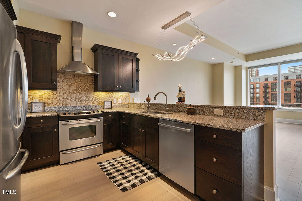 400 West North Street, Unit 604 Raleigh, NC 27603 - Photo 17 of 46 a kitchen with stainless steel appliances granite countertop a sink stove and refrigerator
