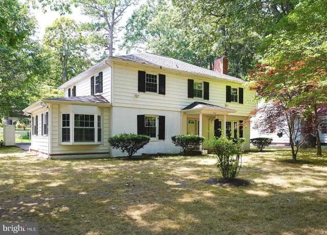 a view of a yard in front of a brick house with large windows