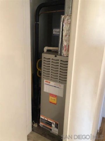a view of an empty room with wooden floor and fan
