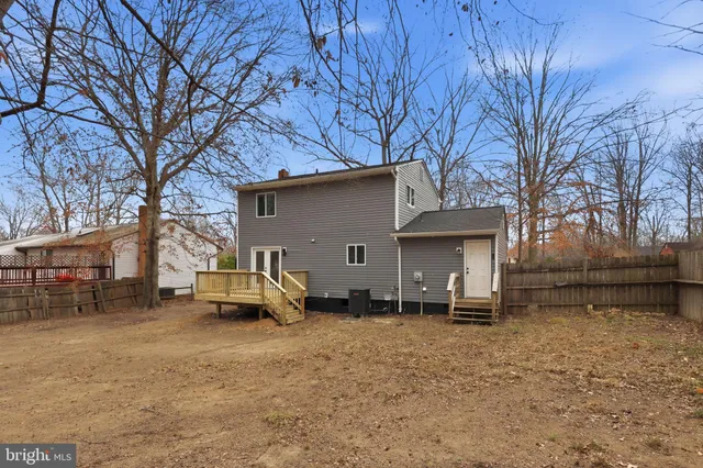 an empty room with wooden floor ceiling fan and windows