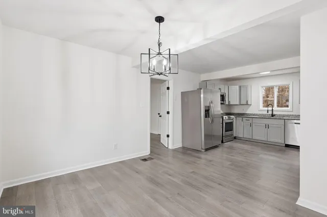 a kitchen with stainless steel appliances granite countertop white cabinets a refrigerator and a stove