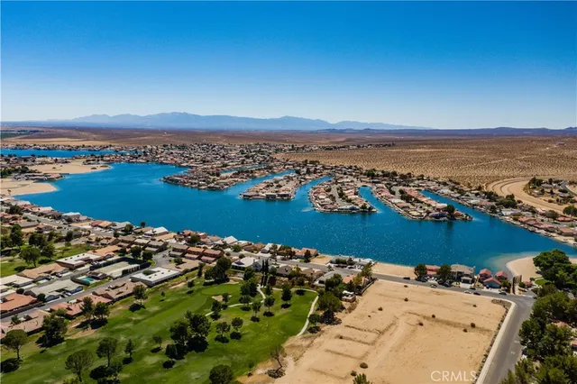 an aerial view of ocean and residential houses with outdoor space