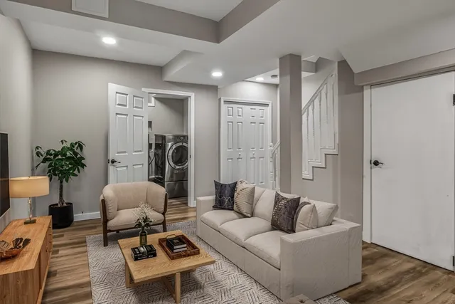 a living room with furniture a rug and a potted plant