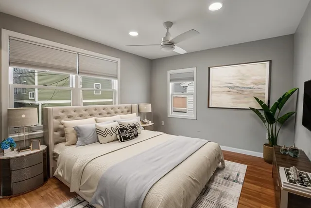 a bedroom with a large bed potted plant and a window