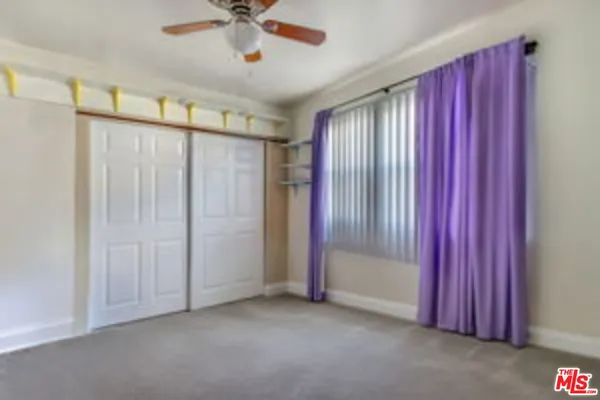 a view of a livingroom with a chandelier fan and windows