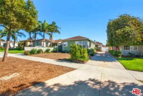a view of a house with a yard and potted plants