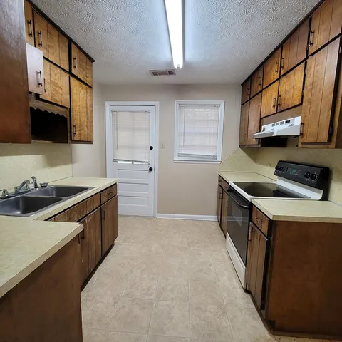 a kitchen with stainless steel appliances a stove a sink and a microwave