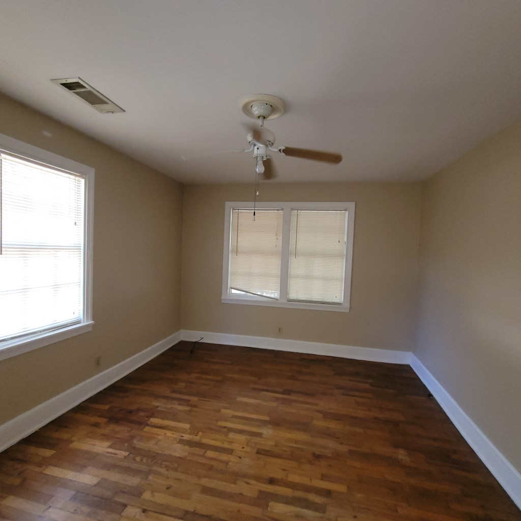 1703 39th Street, Unit B Columbus, GA 31904 - Photo 6 of 8 a view of an empty room with wooden floor and a window
