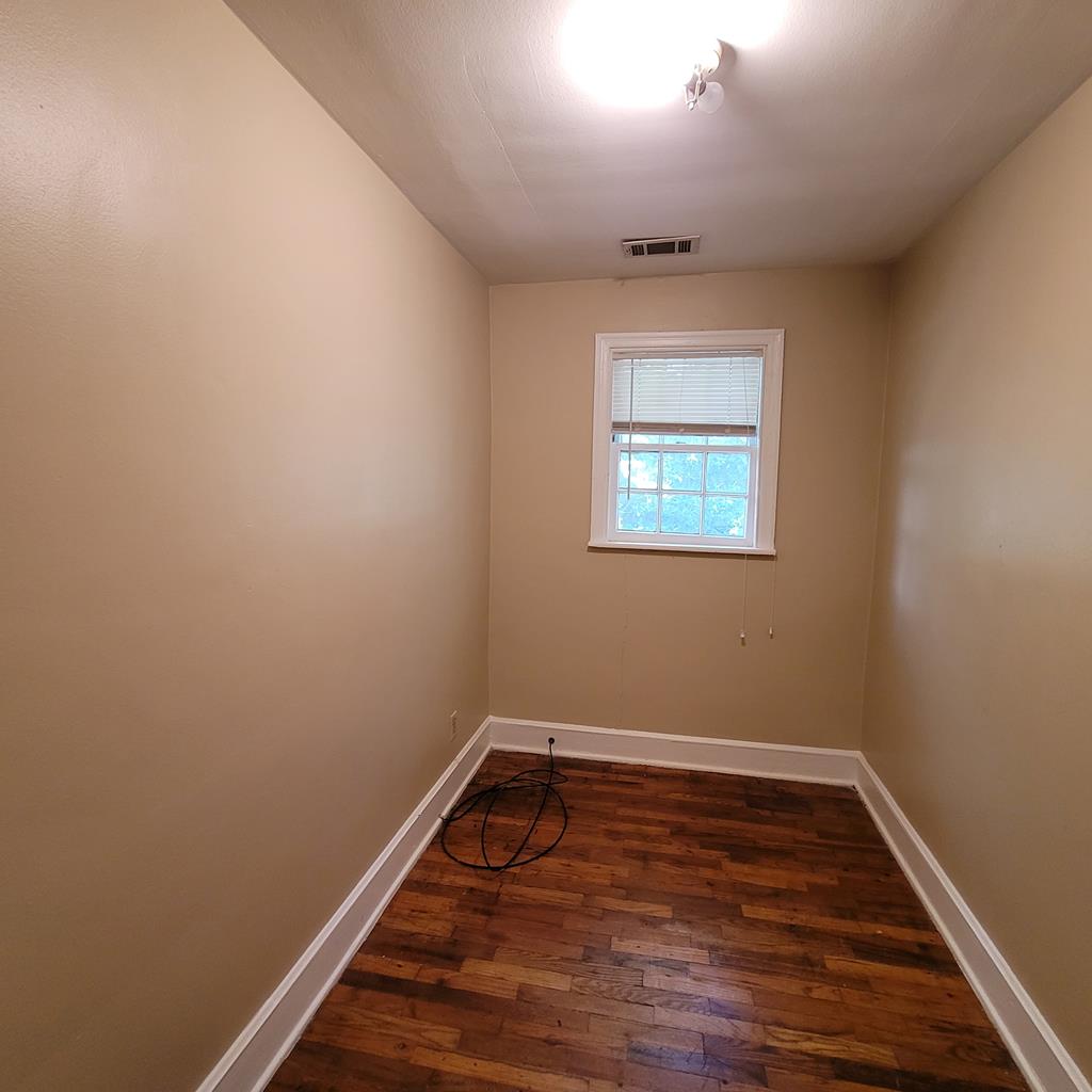 1703 39th Street, Unit B Columbus, GA 31904 - Photo 7 of 8 wooden floor in an empty room with a window
