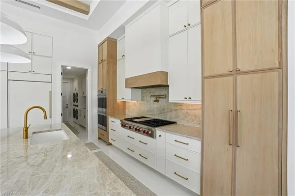a large kitchen with kitchen island a large counter top space appliances and cabinets