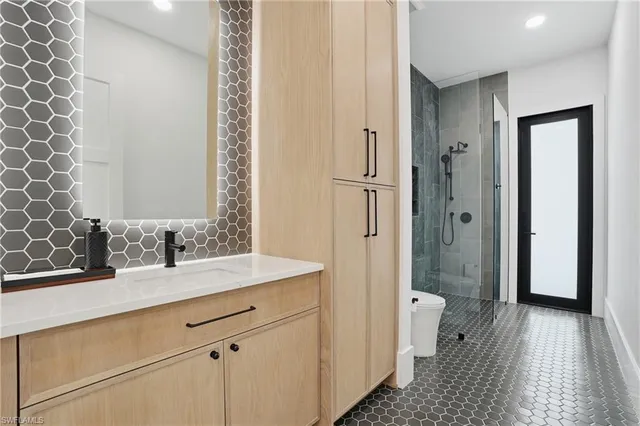 a bathroom with a sink a toilet and shower