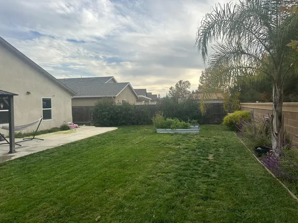 a backyard of a house with table and chairs