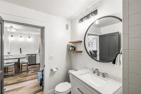 a bathroom with a toilet a sink and mirror