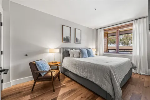 a bedroom with a bed and wooden floor