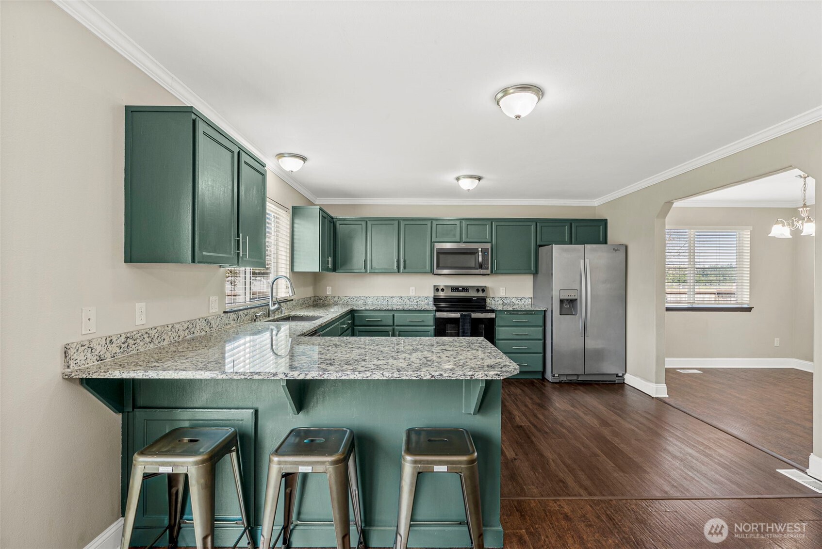 9115 Paradise View Street Yelm, WA 98597 - Photo 13 of 40 a kitchen with stainless steel appliances granite countertop a table chairs sink and cabinets