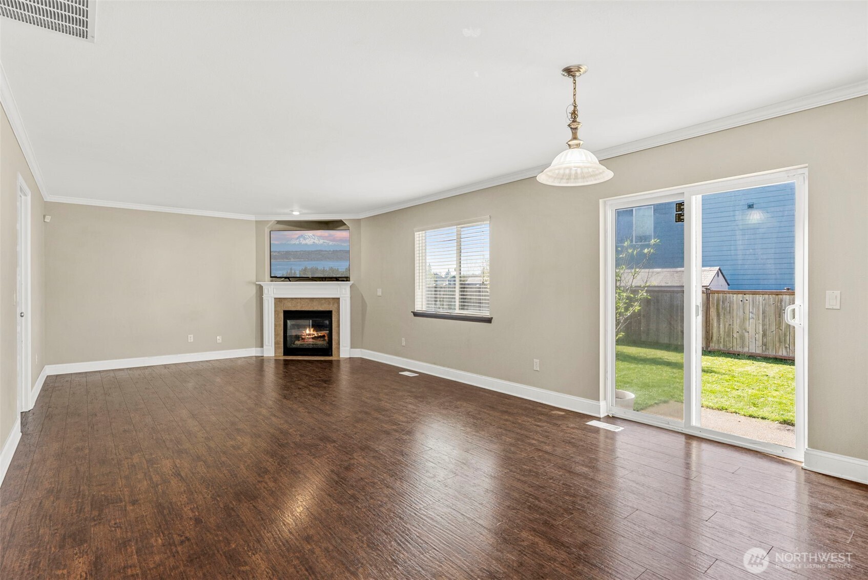 9115 Paradise View Street Yelm, WA 98597 - Photo 15 of 40 a view of an empty room with wooden floor fireplace and a window