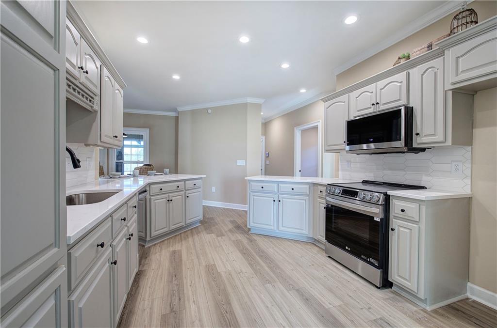 264 Boone Ford Road Southeast Calhoun, GA 30701 - Photo 15 of 66 a large kitchen with stainless steel appliances granite countertop a stove and a sink