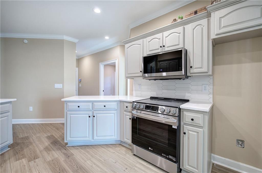 264 Boone Ford Road Southeast Calhoun, GA 30701 - Photo 16 of 66 a kitchen with cabinets stainless steel appliances and wooden floor