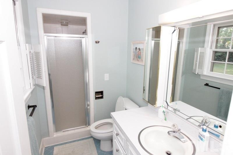6921 Electra Drive Raleigh, NC 27607 - Photo 17 of 22 a bathroom with a granite countertop sink toilet and shower
