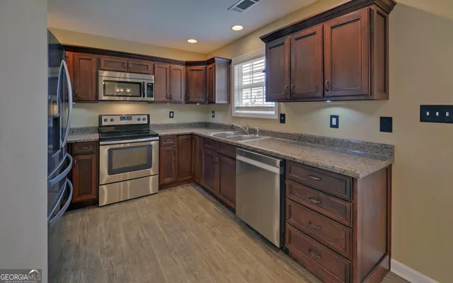 a kitchen with granite countertop stainless steel appliances and wooden cabinets