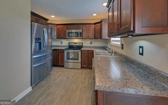 a kitchen with stainless steel appliances granite countertop a stove top oven a sink and dishwasher