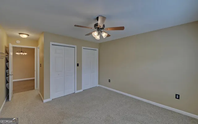 an empty room and chandelier fan