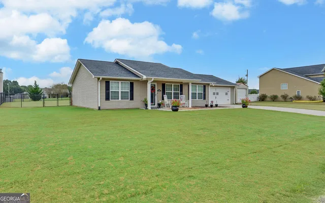 a view of a house with a big yard and large trees