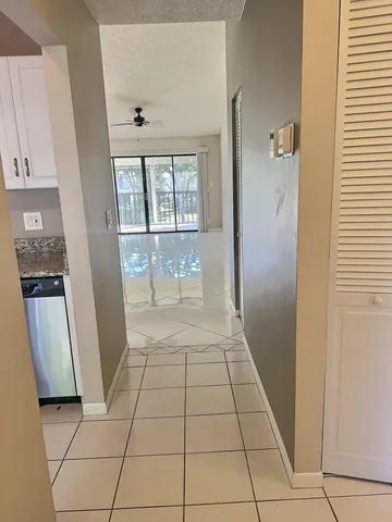 a kitchen with granite countertop a stove and white cabinets