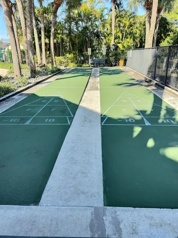 a view of a tennis ground with large trees
