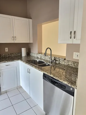 a kitchen with granite countertop a sink and a stove