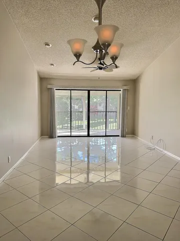 a view of a livingroom with a chandelier fan and windows