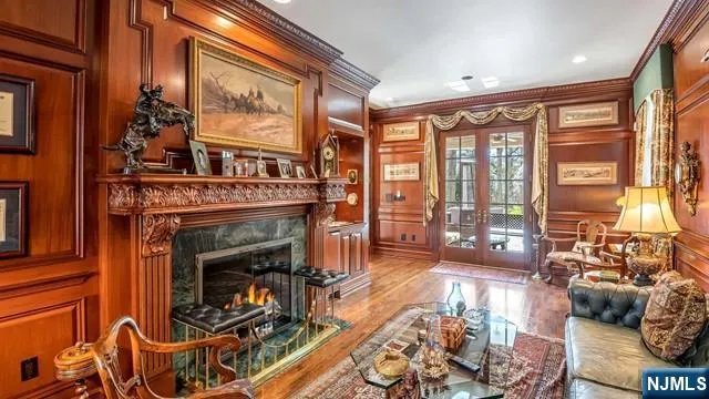 a living room with furniture a fireplace and floor to ceiling windows
