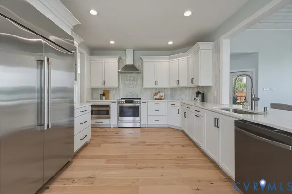 a kitchen with a white cabinets counter top space a sink and stainless steel appliances